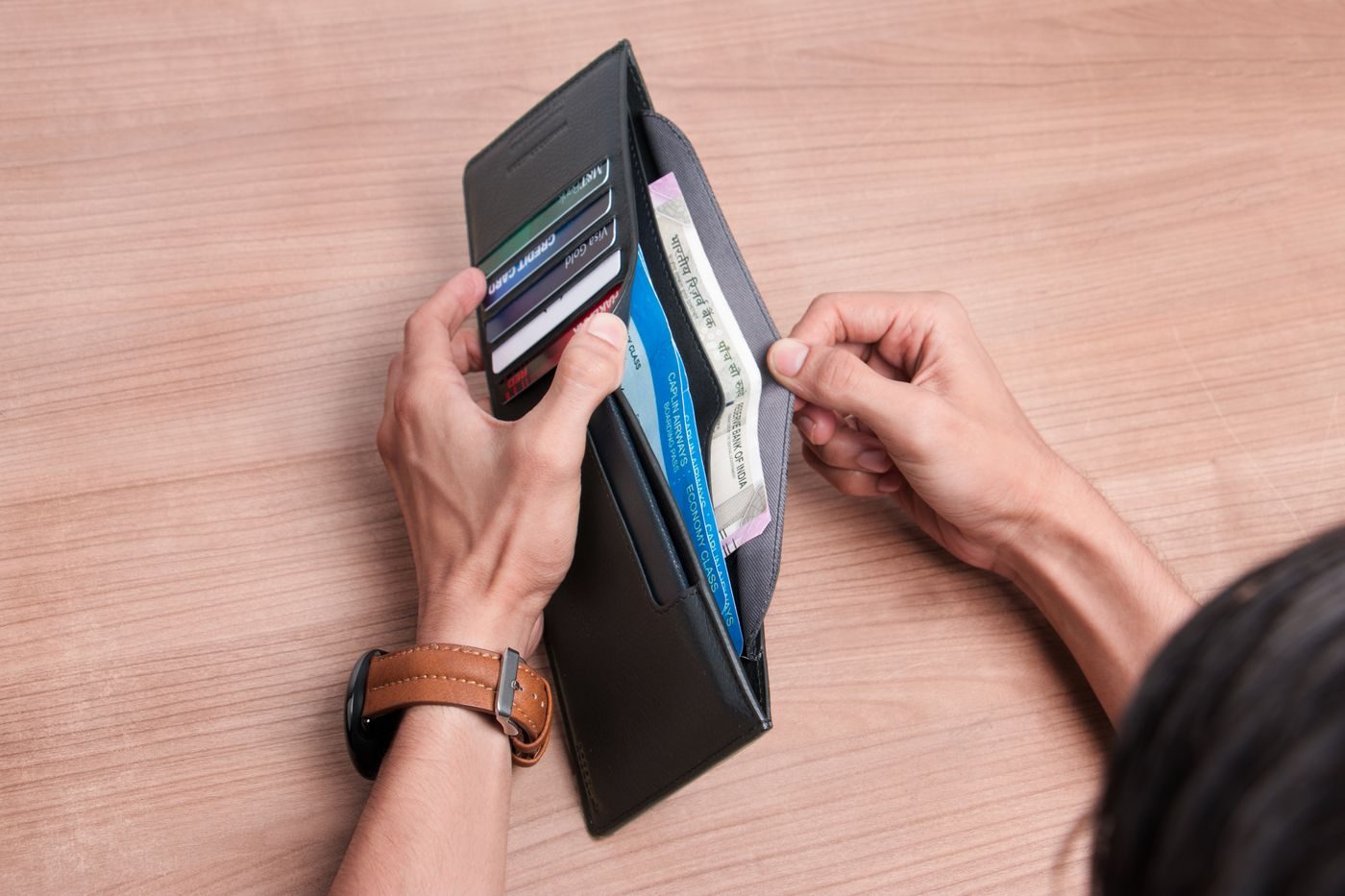 Una cartera con tarjetas y billetes sobre la mesa